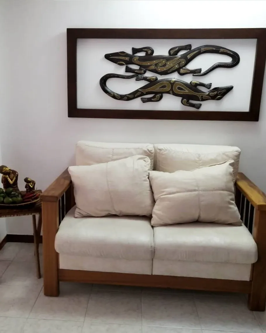 Sofá de dos puestos en color crudo, en la sala de una casa