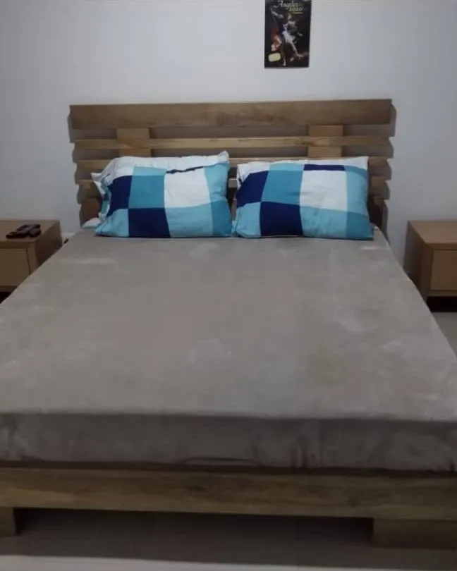 Cama doble con cabecero en tablones de madera